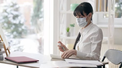 Woman in Mask Cleans Office Desk