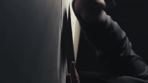 Person Linking Notes on a Wall at Night