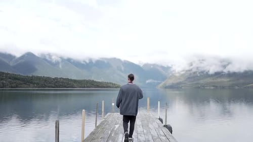 Confident photographer walking along pier
