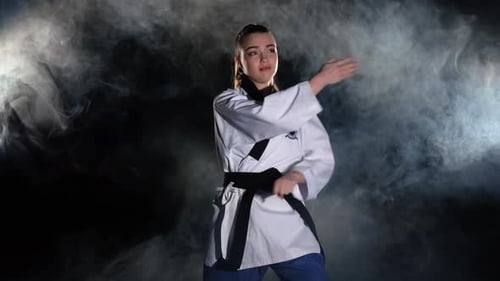 Karate Kick Girl im Kimono üben technische Aufnahmen.
Schwarz