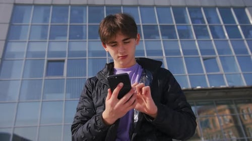 Young Guy With Phone On The Street