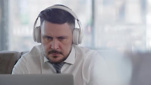 Smiling Man With Laptop Wearing Headphones Indoors