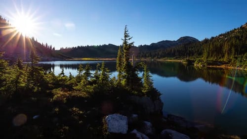Lake Landscape with Sun Shining Over the Mountains