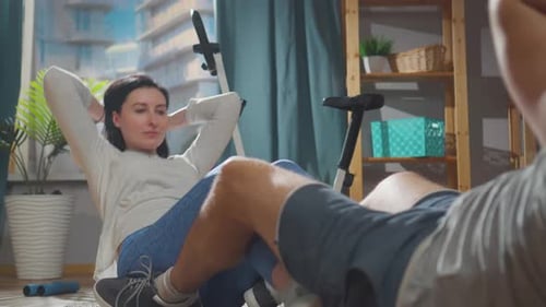 Couple Doing Sit-ups Together in Modern Apartment