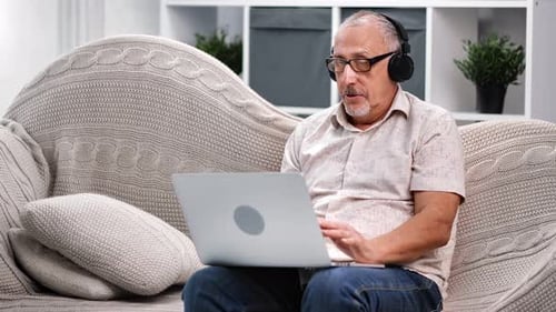 Senior Man Using Laptop for Video Call at Home