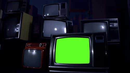 Retro TV Set turning On Green Screen Among Many Vintage Televisions. Dolly Shot. 4K Version.