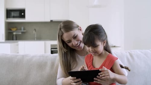 Woman and Child Using Tablet Device at Home