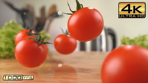 Cherry Tomatoes Falling onto a Wooden Cutting Board