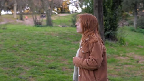 desperate lonely red haired youg woman in the park,looking up
