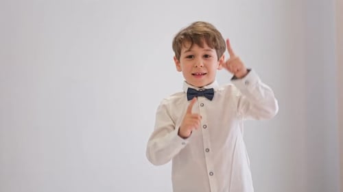 Happy Young Boy with Fingers Pointing Upward