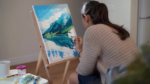 Woman Painting a Mountain Landscape on Easel