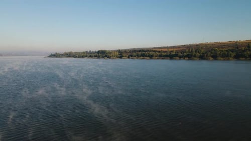 the Drone's Flight Almost Over the Waters of a Foggy Lake