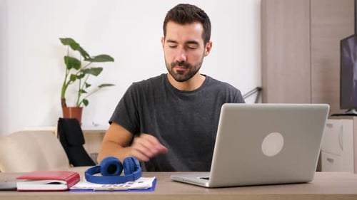 Man Works at Laptop Then Puts on Headphones