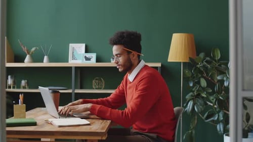 Young Mixed Race Businessman Working on Laptop at Office Desk