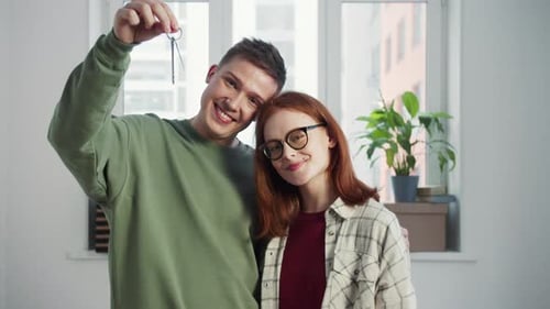 Happy Couple Holding Keys in New Home