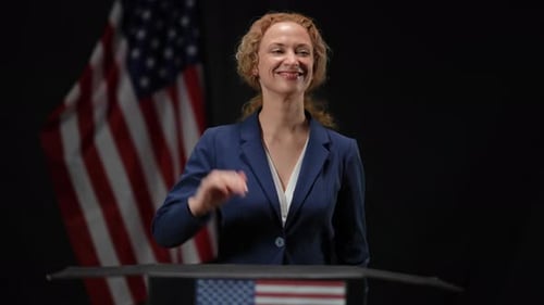 Woman in Blue Suit Clapping at Podium