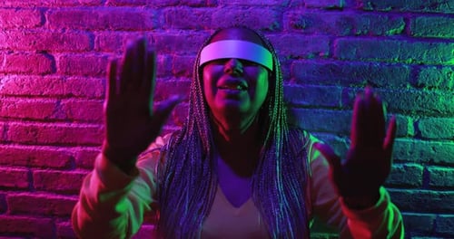 Woman Using VR Headset in Neon Lit Setting