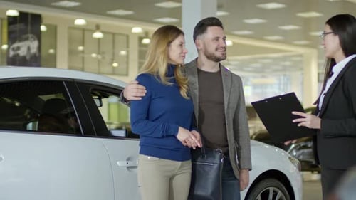 Auto Saleswoman Talking with Couple at Dealership