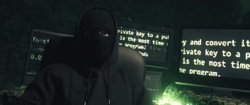 Hacker in Balaclava Sits in Dark Room