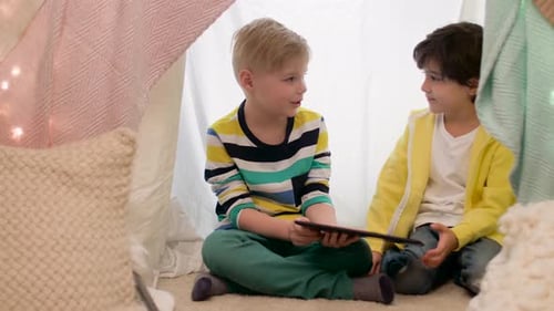 Two Children Using Tablet in Homemade Tent