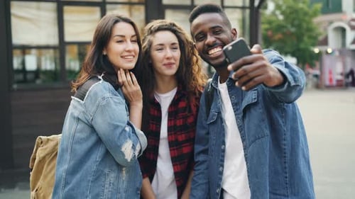Happy Male and Female Tourists Multiethnic Group Are Taking Selfie Standing in the Street