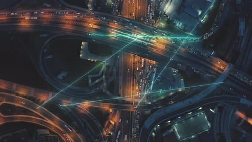 Vue panoramique de haut en bas d'un échangeur routier achalandé à plusieurs voies et à plusieurs niveaux la nuit
