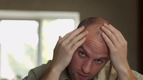 Worried Man Looking at Thinning Hair Close Up