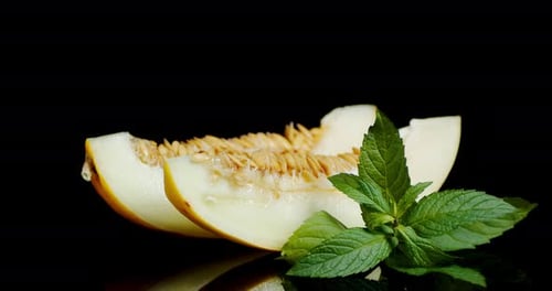 Les tranches de melon mûr avec les feuilles tourneront lentement