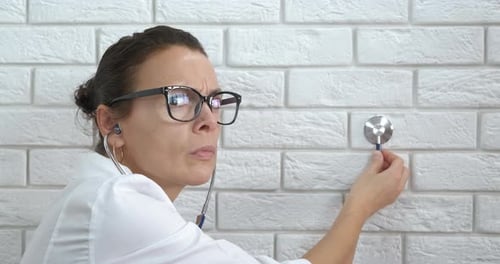 Female Doctor Examines with Stethoscope in Office