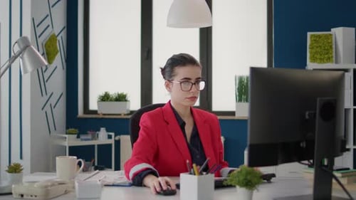 Young Adult Woman Works at Computer in Modern Office