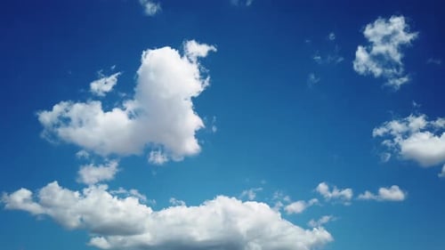 Fluffy White Clouds Float on a Sunny Blue Sky