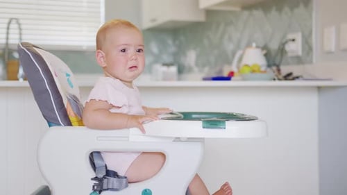 Crying Infant Sitting in Highchair in Bright Home