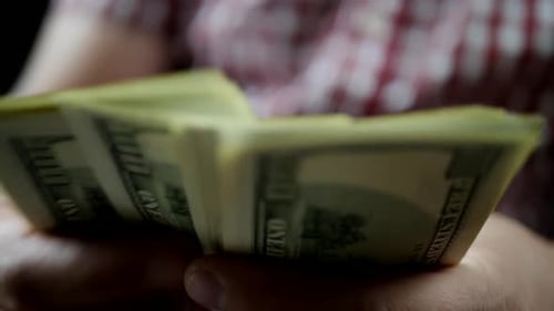 Hands Counting Stack of United States Hundred Dollar Bills