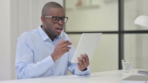 Man Shocked by News on Tablet in Office