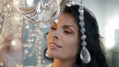 Woman Admiring Ornate Crystal Chandelier Close Up