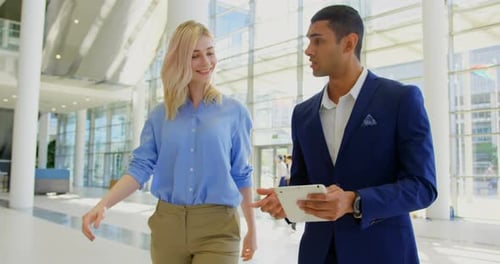 Multi ethnic business people discussing over digital tablet in the lobby at office 4k