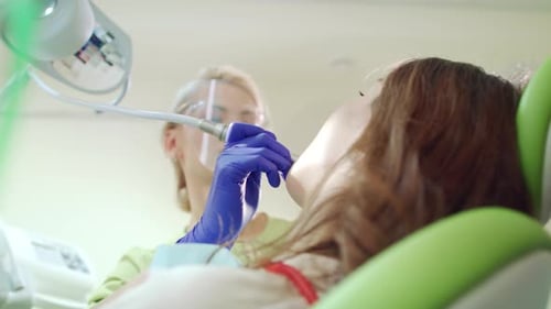Woman Dentist Making Professional Teeth Cleaning in Dental Clinic