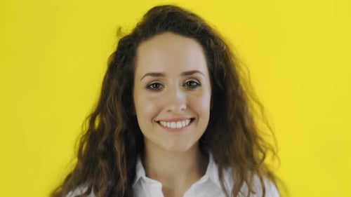 Smiling Young Woman Close Up on Yellow Background