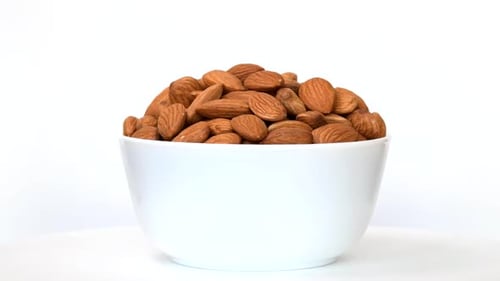 Almonds in bowl rotating on white background