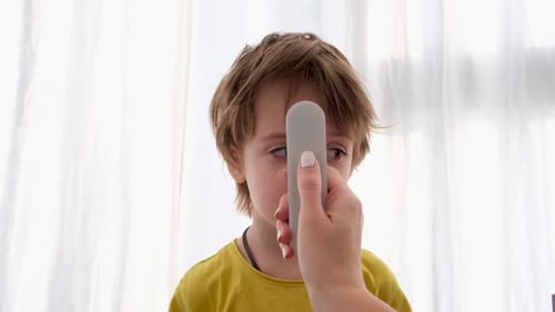 Verwenden eines Infrarot-Thermometers zur Messung der Körpertemperatur des Kindes