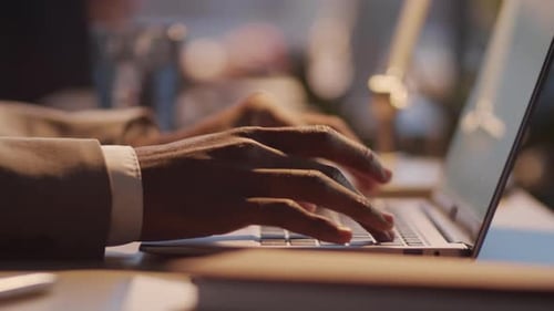 Hands Typing on Laptop Keyboard in Office