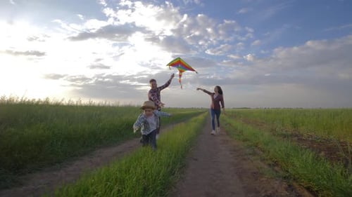 Family Runs with Kite in Rural Grassy Field