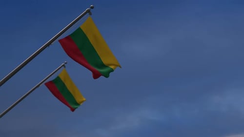 Two Lithuanian Flags Waving Proudly Against a Clear Blue Sky