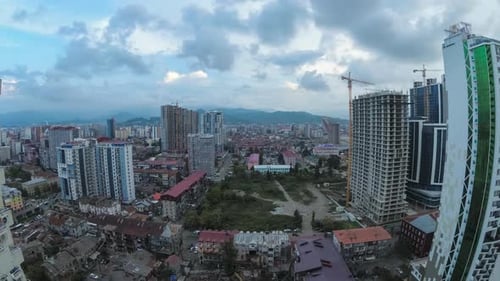 From Day To Night City Space with Construction Site, Skyscrapers, Traffic, and Mountains. Timelapse