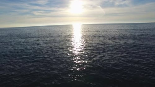 Luftaufnahme einer malerischen Strandstadt und des Ozeans bei Sonnenuntergang.