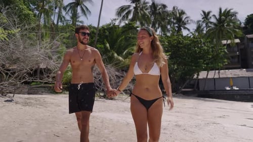 A Zoom Out Shot of a Beautiful Romantic Couple Walking on Beautiful Tropical Beach