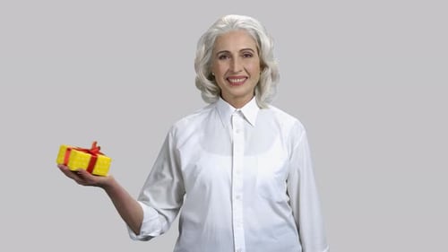 Elegant Senior Woman Presents a Birthday Gift