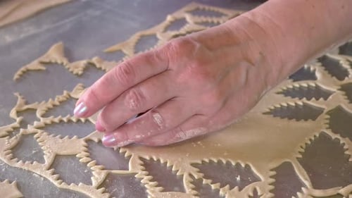 Hand Pressing Dough with Cookie Cutout Shapes