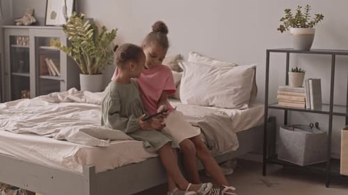 African American Girls Playing Games on Smartphone