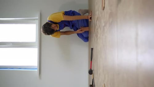 Man Installing Laminate Flooring in a Room